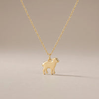 Little Lamb, a sealed 18K gold lamb pendant necklace, on a plain background