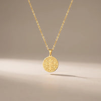 St. Benedict Shield, a sealed 18K gold St. Benedict medal necklace, on a plain background