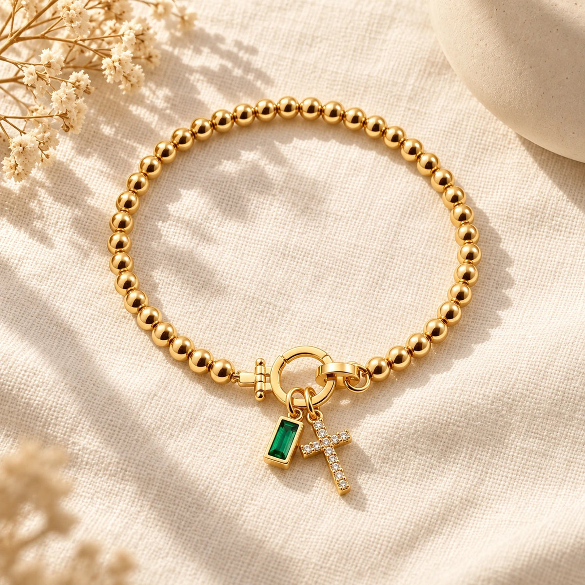Birth Month Crystal Cross Charm Bracelet laid flat on linen