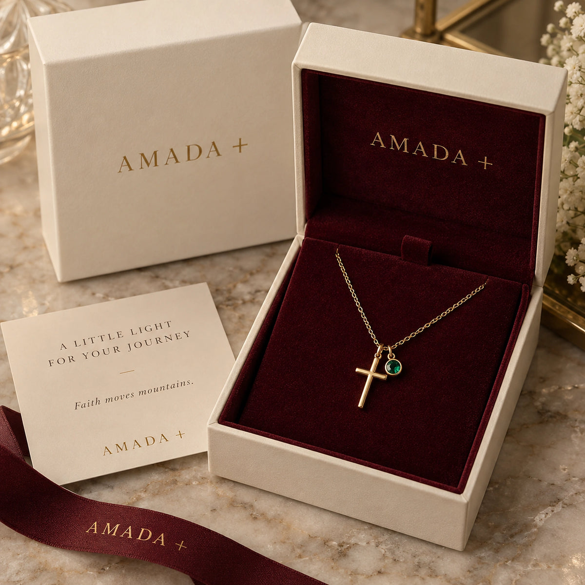 Birthstone Cross Necklace displayed in an Amada gift box.