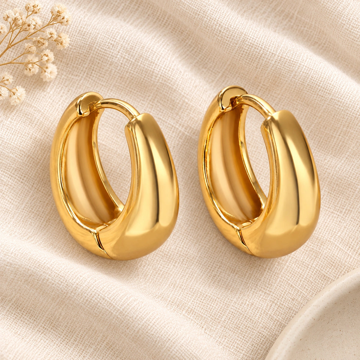 Amada Chunky Hoop Earrings laid flat on fabric.