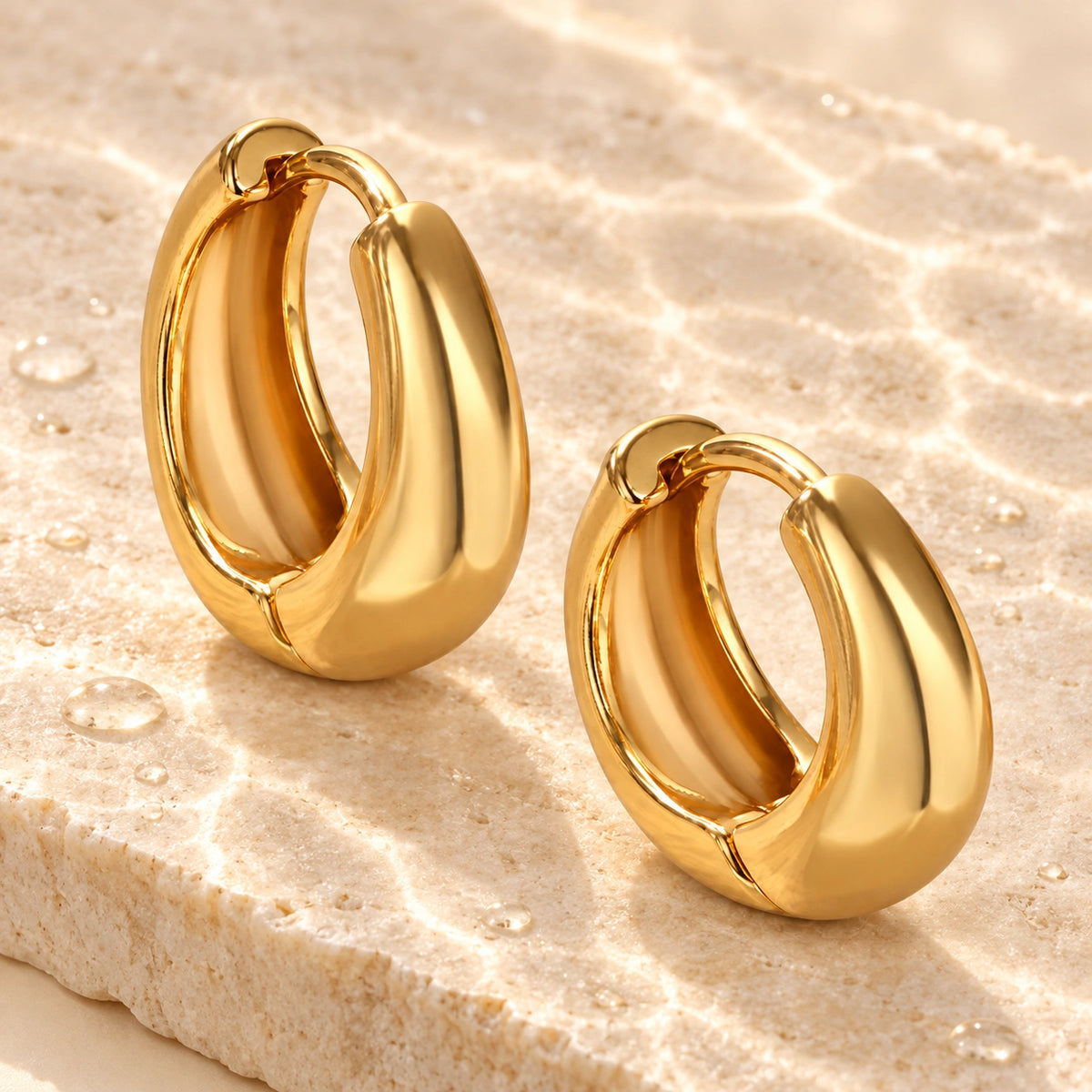 Amada Chunky Hoop Earrings in a styled still life with water droplets.