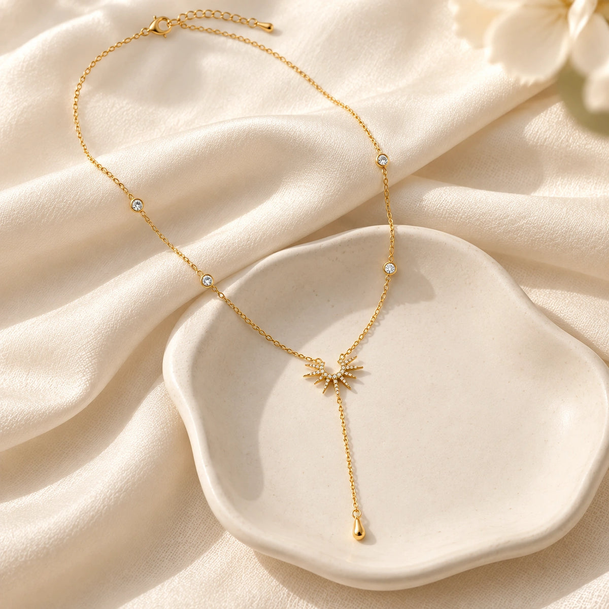 Amada Sunburst Lariat Necklace laid flat on fabric.