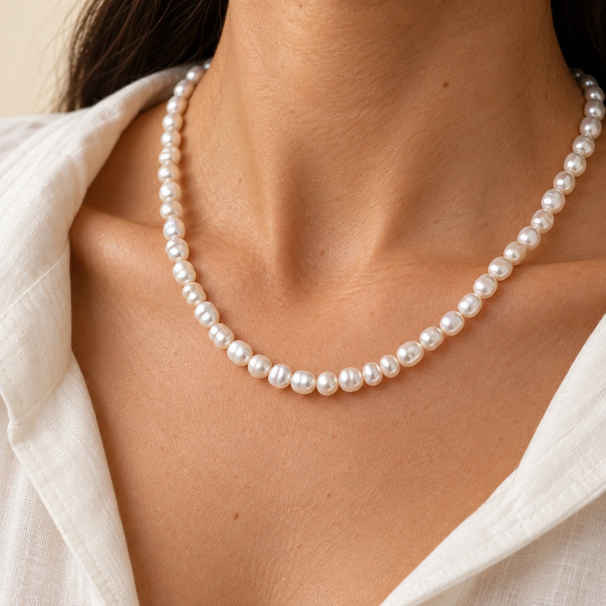 Amada Faux Pearl Strand Necklace worn by a woman, shown close up.