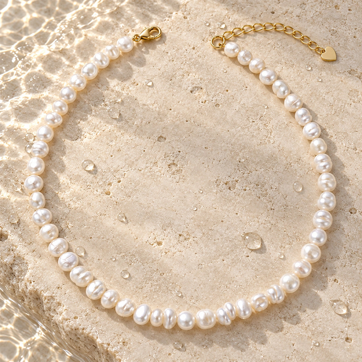 Amada Faux Pearl Strand Necklace in a styled still life with water droplets.