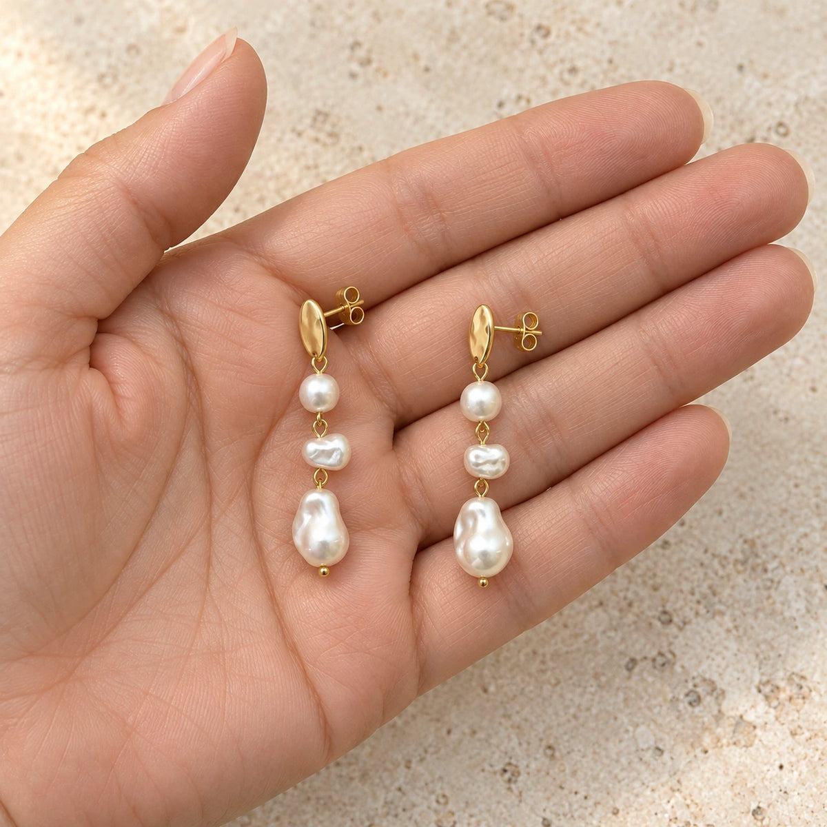 Grace Faux Pearl Drop Earrings held in hand, showing its true scale