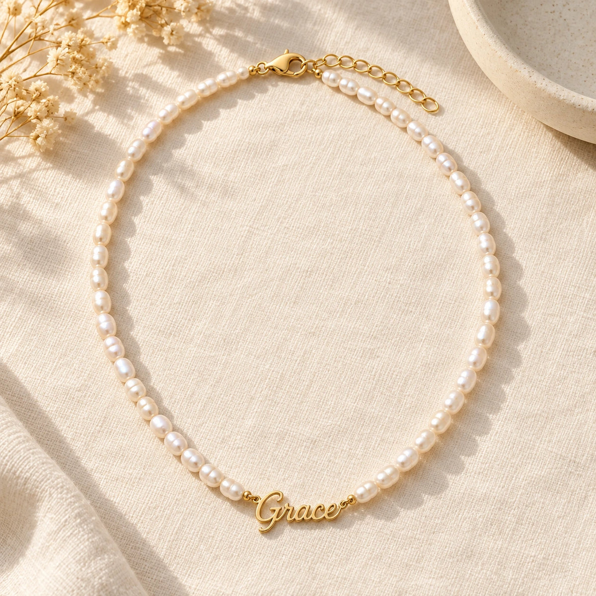 Pearl Name Necklace laid flat on linen