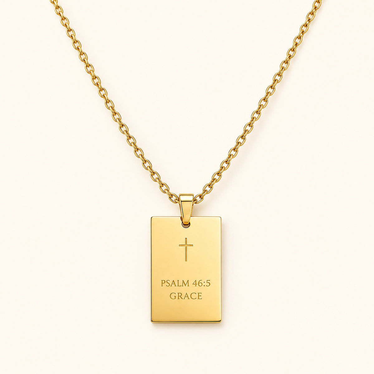 Amada His Promise Necklace in gold with an engraved rectangular pendant on a fine chain, on an ivory background.