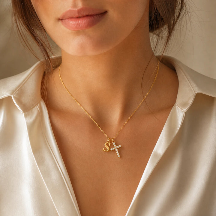 Initial and crystal cross necklace worn with an ivory top
