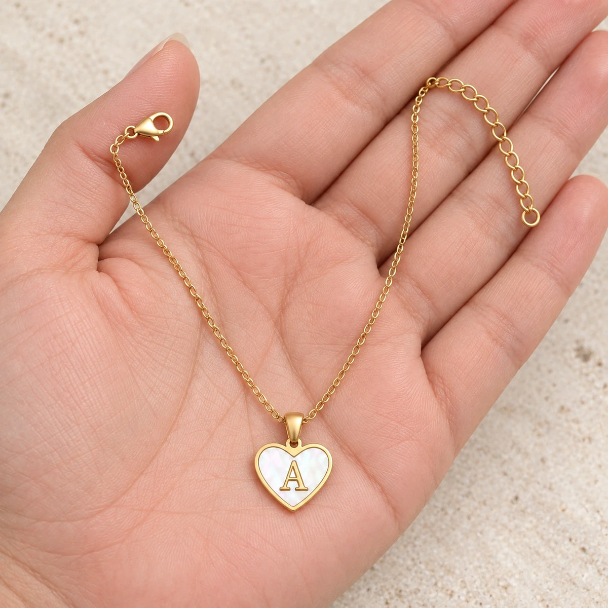 Initial Heart Necklace held in hand, showing its true scale