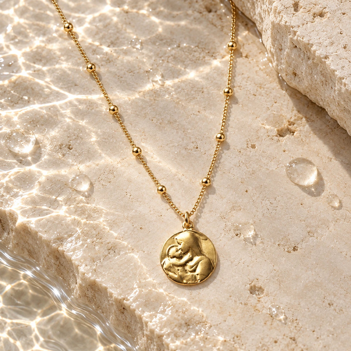 Mother Mary Necklace with water droplets on stone
