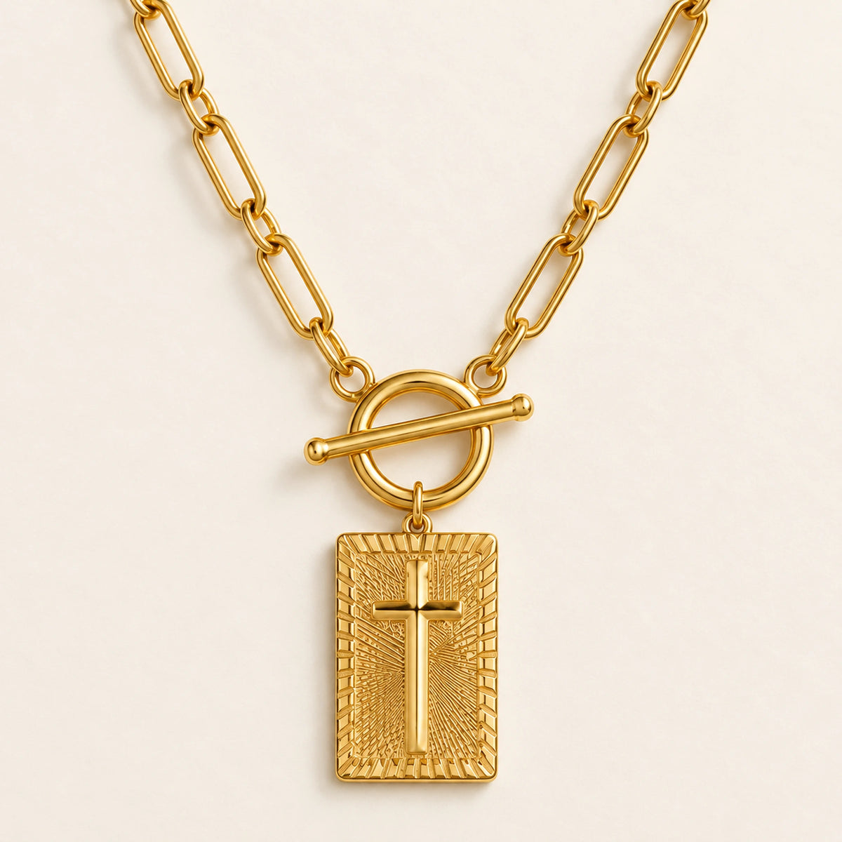 Front close-up of the Amada Nail Cross Necklace showing the raised cross, textured pendant and toggle clasp.