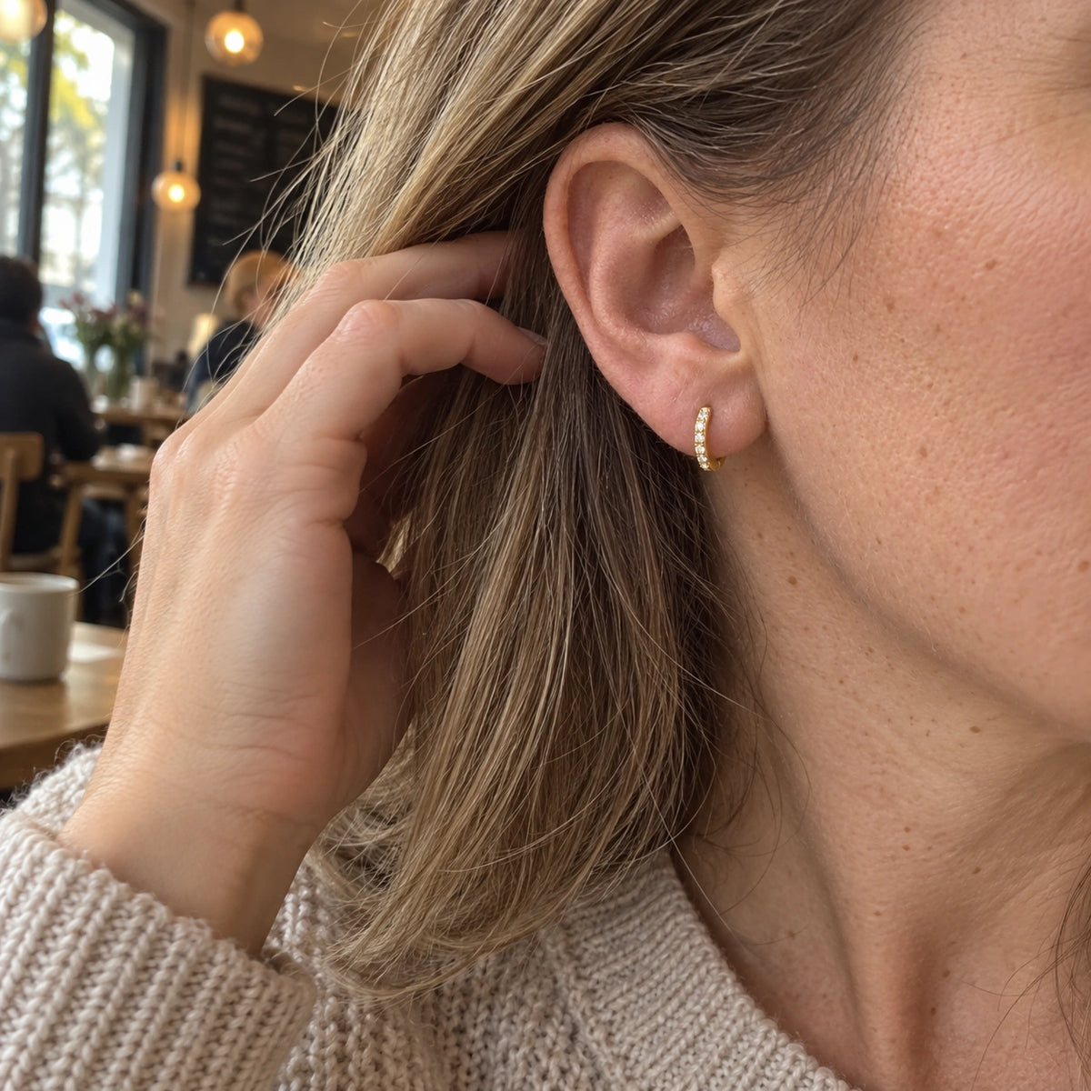 Amada Pave Huggie Earrings worn by a woman, shown from another angle.