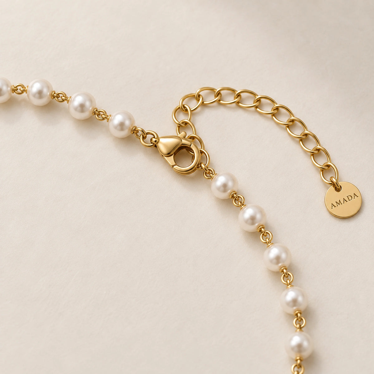 Close-up of the lobster clasp and extender chain of the Pearl Cross of Grace Necklace.