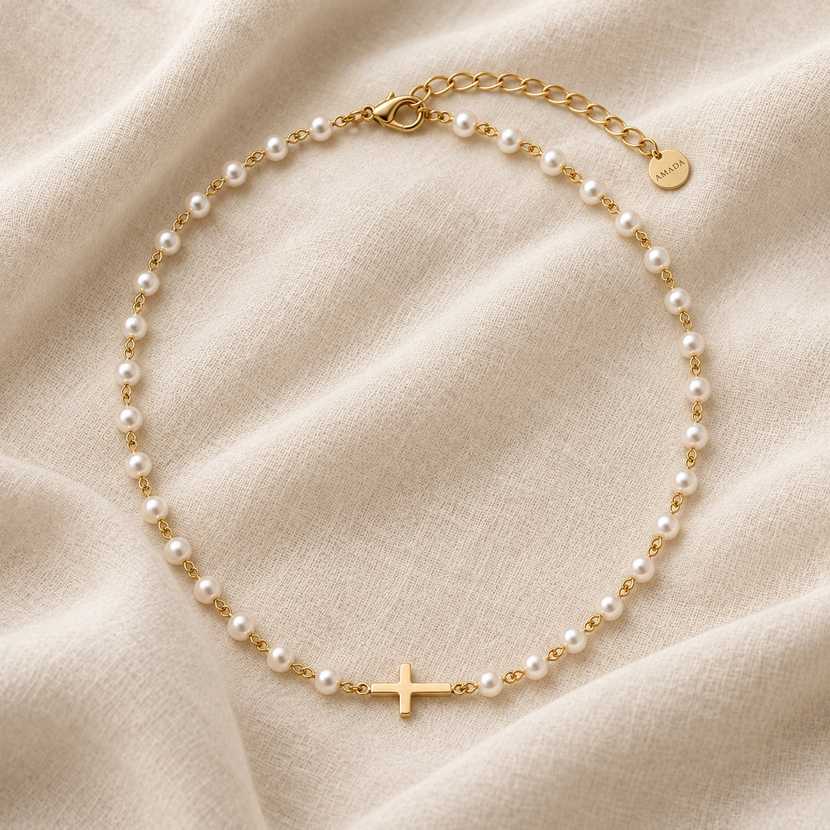 Pearl Cross of Grace Necklace laid on ivory linen.