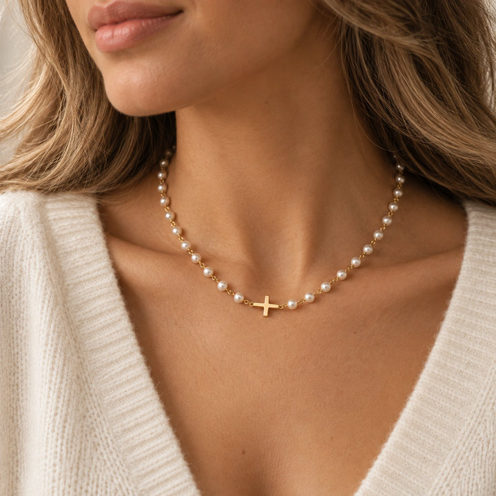 Pearl necklace with a delicate gold-plated cross worn on the body