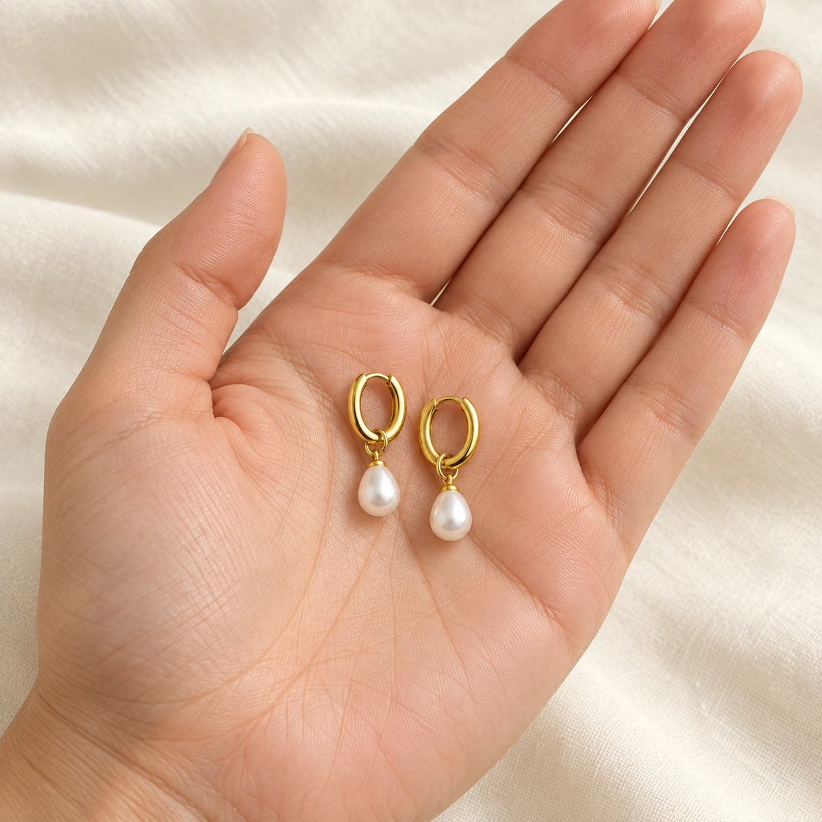 Amada Petite Faux Pearl Huggie Earrings shown up close for a sense of its real size.