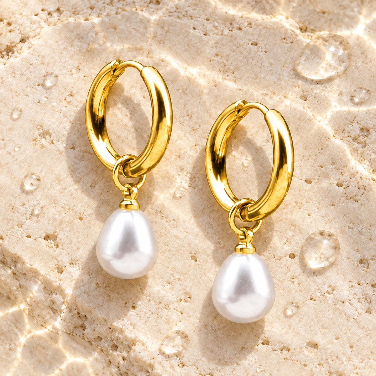 Amada Petite Faux Pearl Huggie Earrings in a styled still life with water droplets.