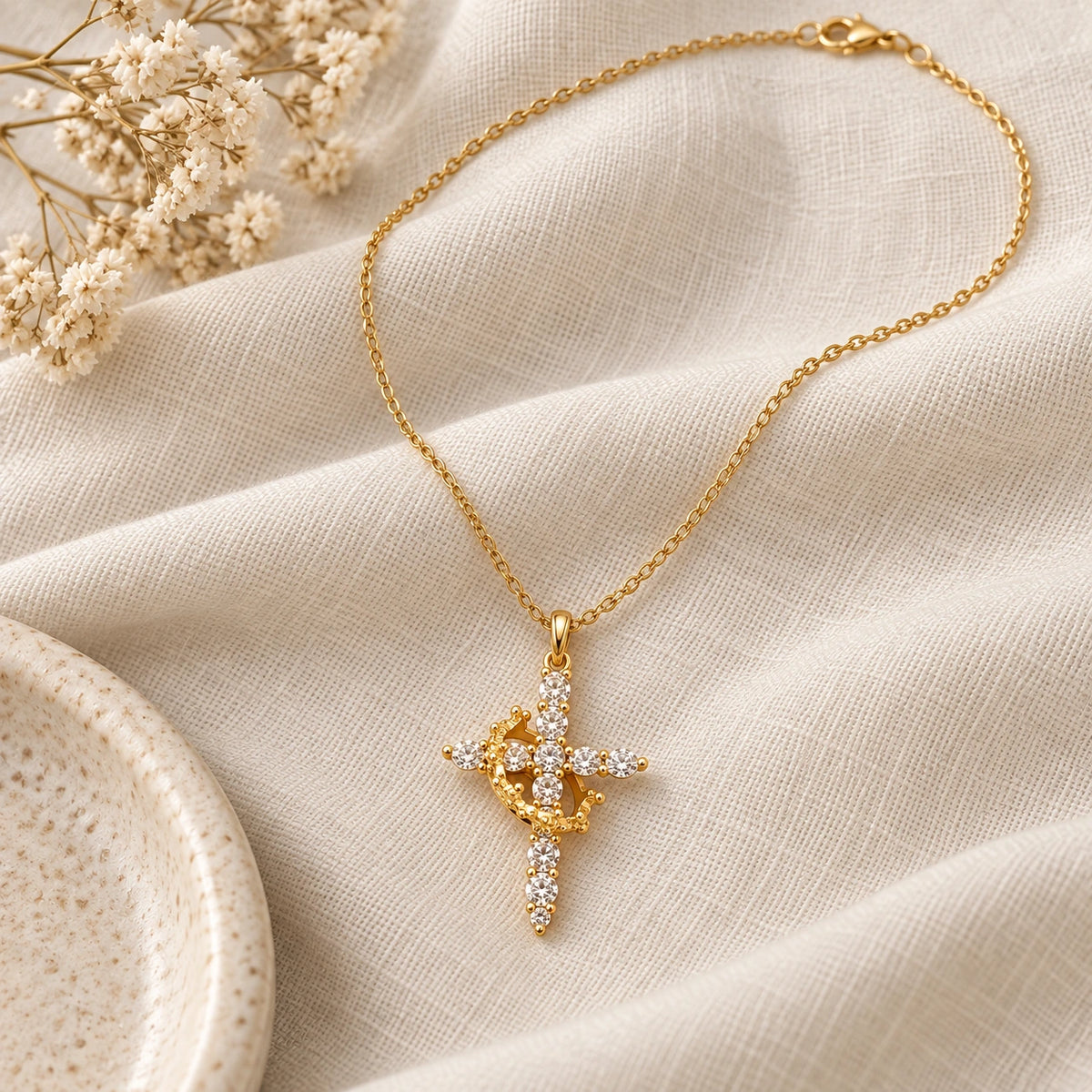 Rotating Crown Cross Necklace laid flat on linen