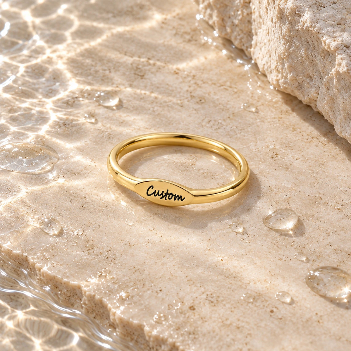 The Initial Ring with water droplets on stone