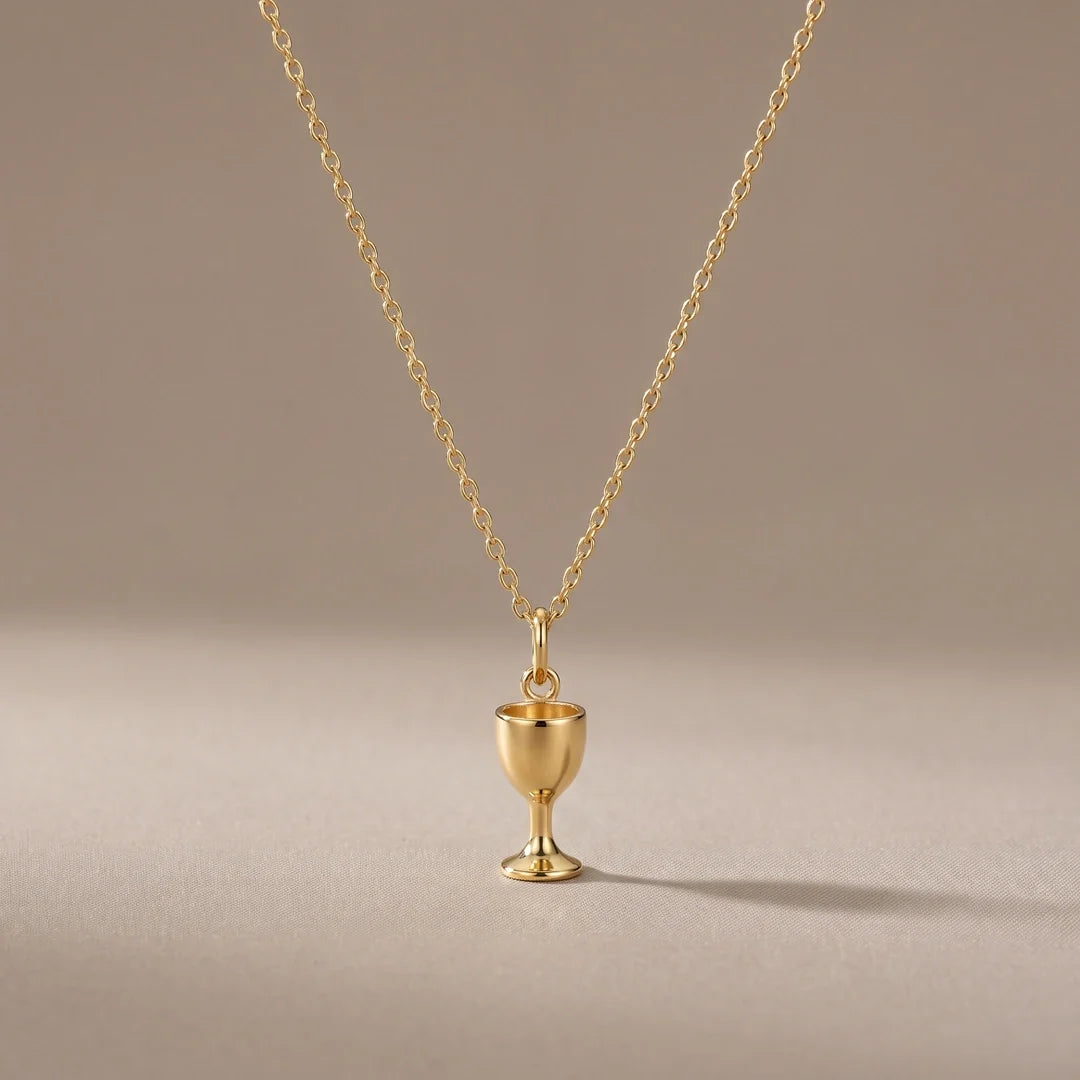 Chalice, a sealed 18K gold chalice pendant necklace, on a plain background