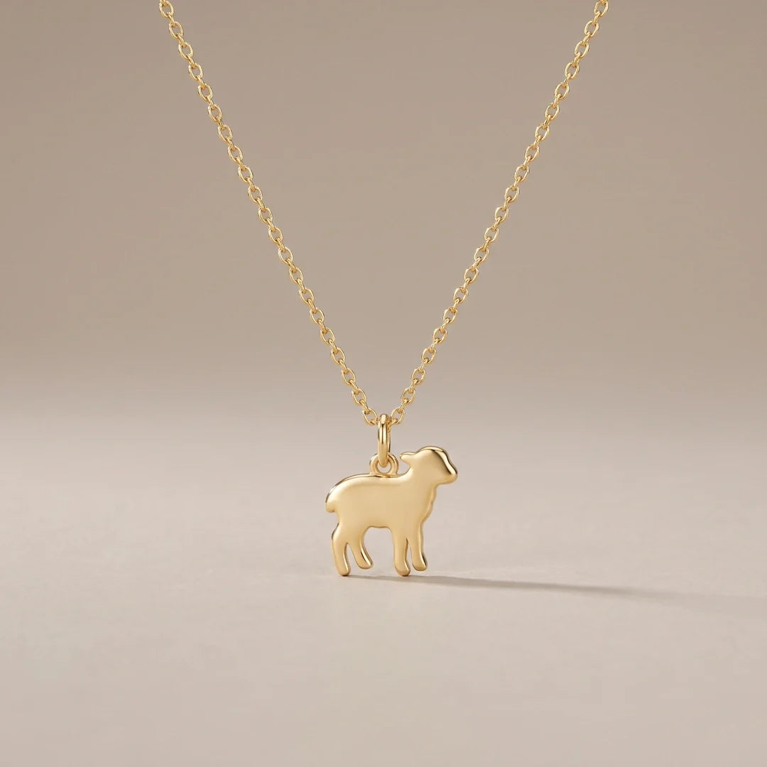 Little Lamb, a sealed 18K gold lamb pendant necklace, on a plain background