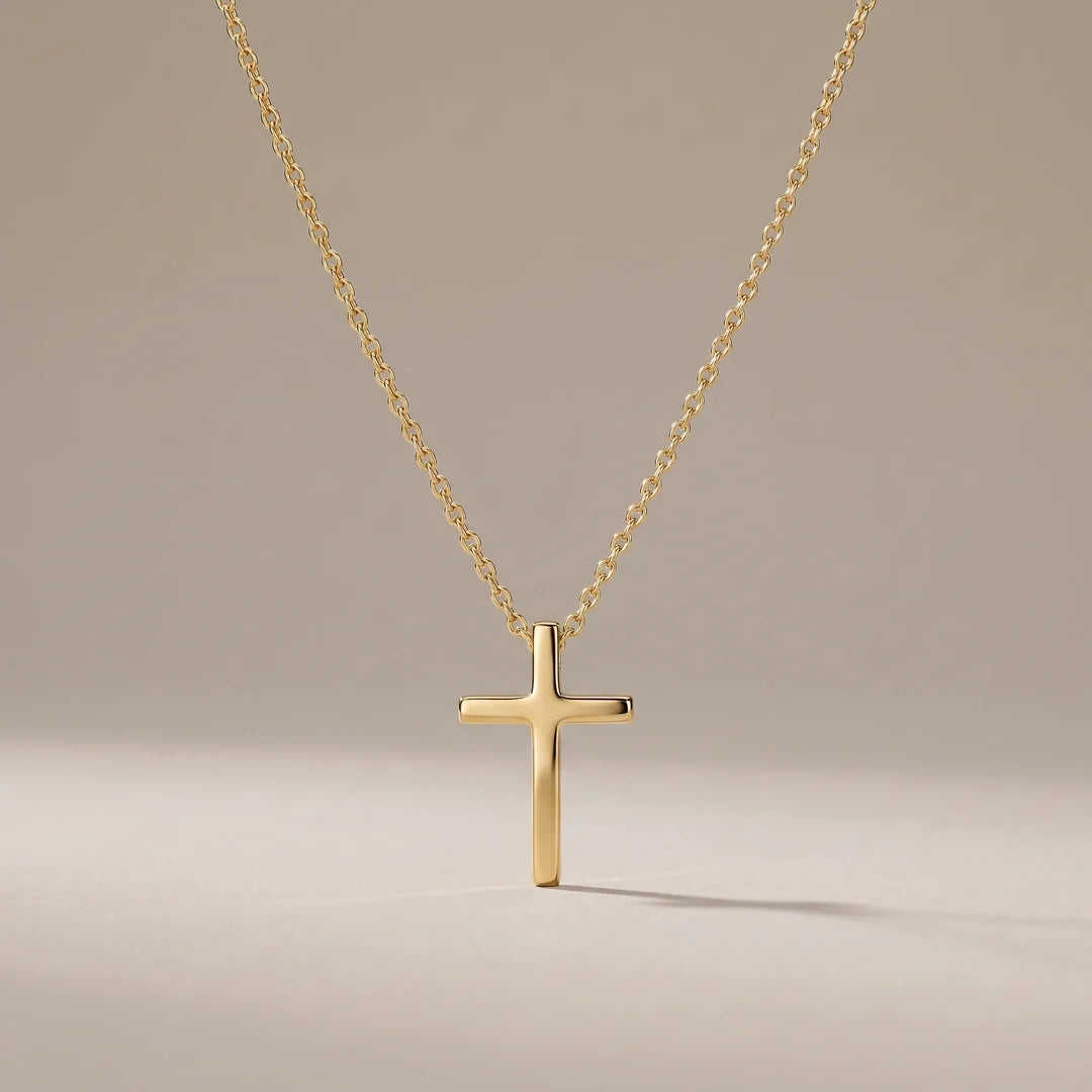 Milestone Cross, a sealed 18K gold cross necklace, on a plain background
