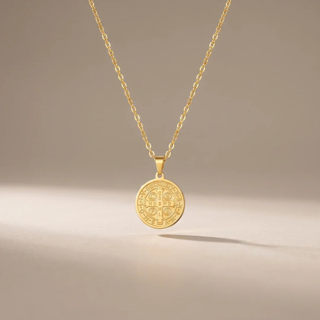 St. Benedict Shield, a sealed 18K gold St. Benedict medal necklace, on a plain background